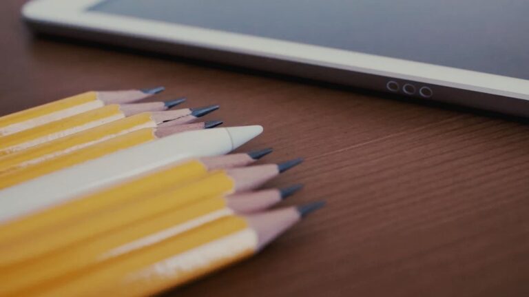 Apple Pencil laying beside wooden pencils. 